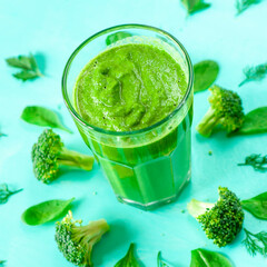 Glass of broccoli juice, on green background