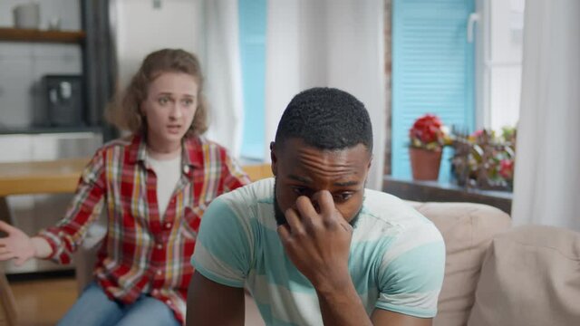 Furious young woman shouting at upset depressed man at home