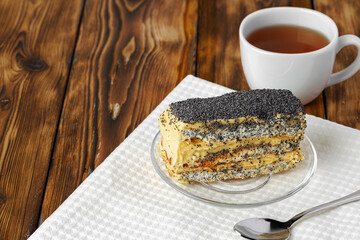 Piece of cake with poppy seeds on glass plate close up