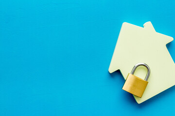Security concept with lock and house figure on blue table top view copy space