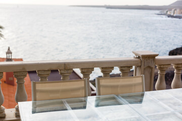 Fototapeta premium table of a restaurant near the sea with the sunset in the background.Concept: summer, freedom, restaurant