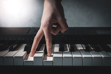 fingers press piano keys close-up, hand of a composer or musician plays a synthesizer