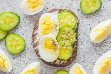 Sandwich with egg, cucumber, sesame seeds and spices. Tasty breakfast. Sandwich on the table