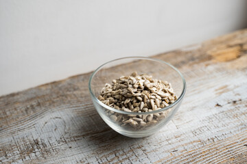 Sunflower seeds in a small plate on the wooden vintage table. Healthy vegetarian protein nutritious food. Sunflower seed on rustic old wood.