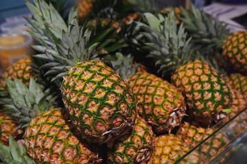 A lot of sweet pineapples at the grocery store. Natural fresh fruit at the market.