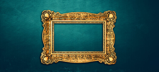 Vintage luxury golden frame with ornate baroque decoration on rustic textured wall background.