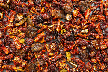 Dried tomatoes background. Texture made of different varieties of dry tomato. Vegetable snacks.