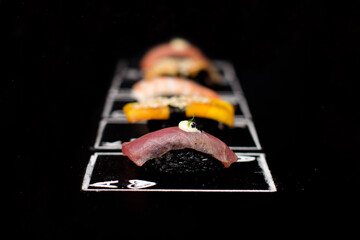 Hand drawn Poker cards, Japanese sushi nigiri with black rice and tuna tataki in focus on chalkboard. Near Different Asian meal. Ace of hearts card with Maguro nigiri.