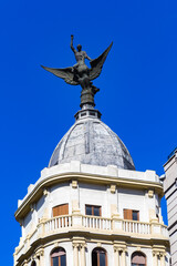 Obraz premium It's Statue on the Hotel on the Gran Via street (Great Way), Madrid, Spain. Gran via is known as the the street that never sleeps or as Spanish Brodway