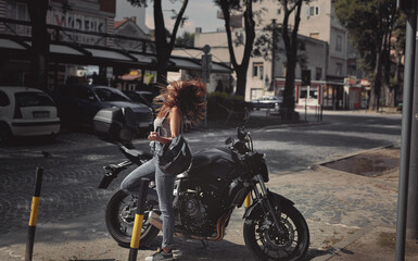Fototapeta premium Young attractive girl with the motorbike enjoys the sun