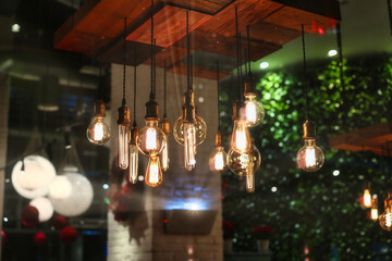 closeup on group of different Vintage Edison Light Bulb types illuminated in a dark environment