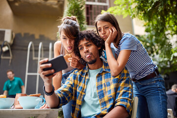Young man taking a selfie with his friends
