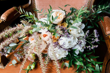 The bride's wedding bouquet lies on a chair.