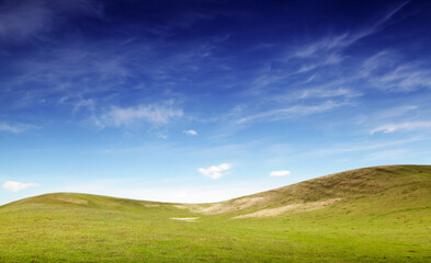 landscape with green hills and blue sky.