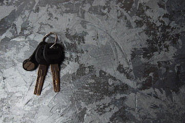 Keys to the house or apartment on a gray concrete background with copy space, view from the top of...