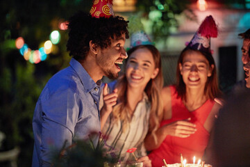 Group of friends with funny hats at birthday party