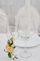 Table setting with sparkling wineglasses, plate with white napkin and cutlery on table, copy space. Place set at wedding reception. Table served for wedding banquet in restaurant