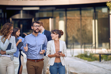 Obraz premium cropped image of businesspeople walking, talking and laughing