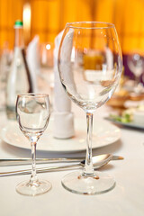 Table setting with sparkling wineglasses, plate with white napkin and cutlery on table, copy space. Place set at wedding reception. Table served for wedding banquet in restaurant