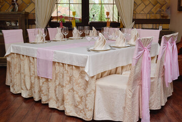 Table setting with sparkling wineglasses, plates and cutlery on table, copy space. Place set at wedding reception. Table served for banquet in restaurant