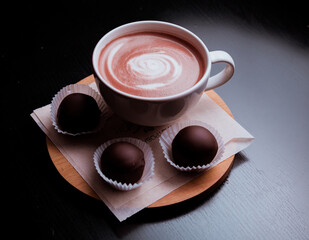 Cacao with latte-art on the table and candy