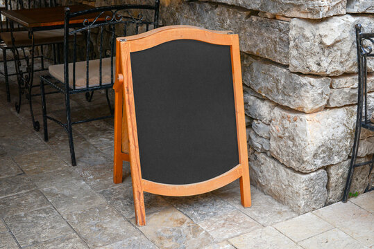 Restaurant blank menu board for offer promotion. Old city street with stone walls and floor
