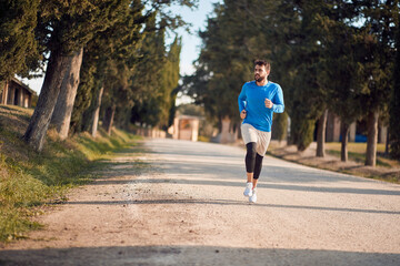 young caucasian adult man jogging in beautiful region of italy