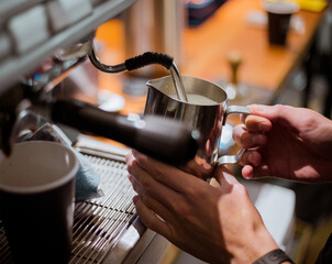 Fototapeta na wymiar Closeup image of male hands pouring milk and preparing fresh cappuccino