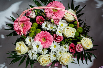 top view on beautiful bouquet of assorted flowers served in wicker basket