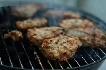 Feuer brennt im Grill und Fleisch wird auf dem Grill gekocht