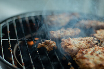 Feuer brennt im Grill und Fleisch wird auf dem Grill gekocht