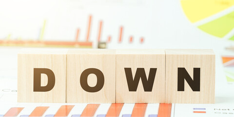 word down made with black letters on wooden blocks on desk