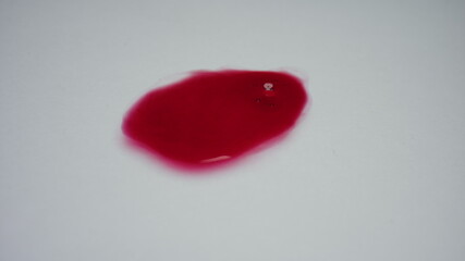 Red liquid on white background. Closeup blood drop with bubbles