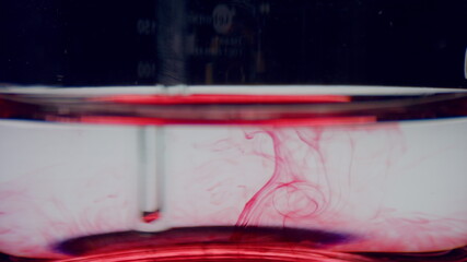 Test tube with water and red reagent. Closeup laboratory glassware with blood