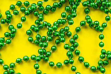 Green string of beads on a yellow background, Christmas decoration