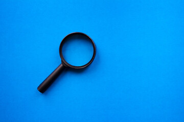Black magnifier on a blue background