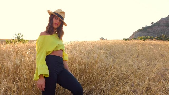Ragazza con vestito giallo balla in un sentiero di campagna con pantaloni nero