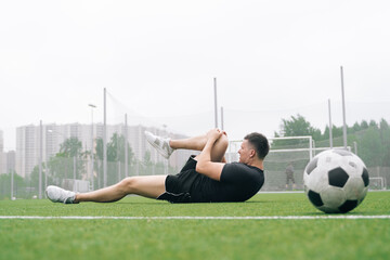 soccer player A man holds his knee. Dislocation of the knee joint.