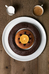 A double doughnut, coffee and milk on a wooden table.