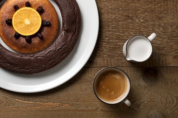A double doughnut, coffee and milk on a wooden table.