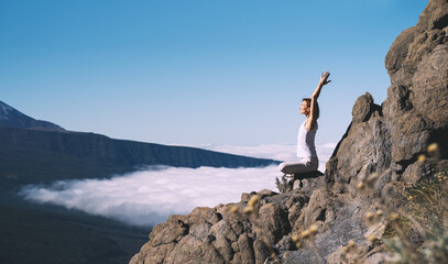 Woman doing yoga and meditating on background of natural landscape