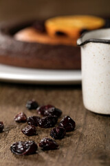 A double doughnut, coffee, milk, chocolate and cranberries on a wooden table.