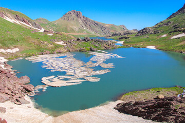 snowy mountains, blue water and blue sky
