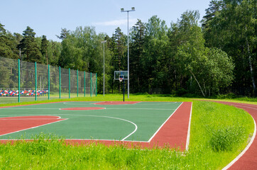 Empty street basketball court in the park on the sunny summer day.