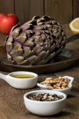 Ingredients for artichokes' salad with walnuts, pepper, apple, lemon and olive oil.