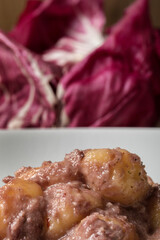 Gluten free potato dumplings with radicchio sauce and walnuts.