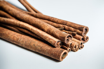 closeup large heap of dry cinnamon sticks served on white table surface