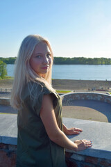 Fototapeta na wymiar beautiful blond young woman standing in front of river