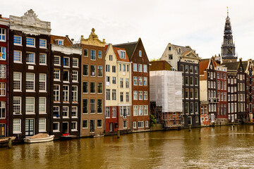 Fototapeta na wymiar Buildings in front if the Damrak street, Amsterdam, the capital of the Kingdom of Netherlands