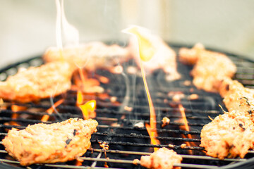 Feuer brennt im Grill und Fleisch wird auf dem Grill gekocht